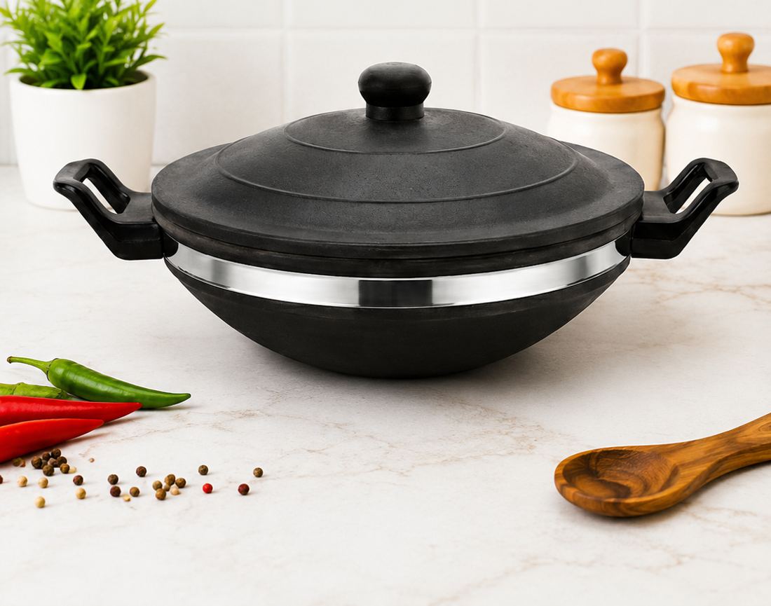 Black clay kadai with lid on a kitchen counter