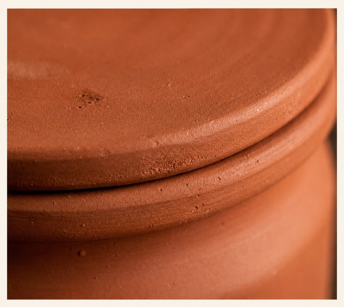 Close-up of the smooth fired texture of a clay pot and lid